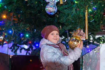 Poster - A child stands near the Christmas tree on New Year's holidays. 