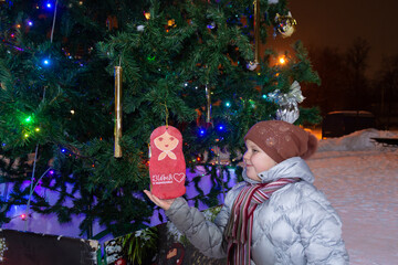 Poster - A child stands near the Christmas tree on New Year's holidays. 