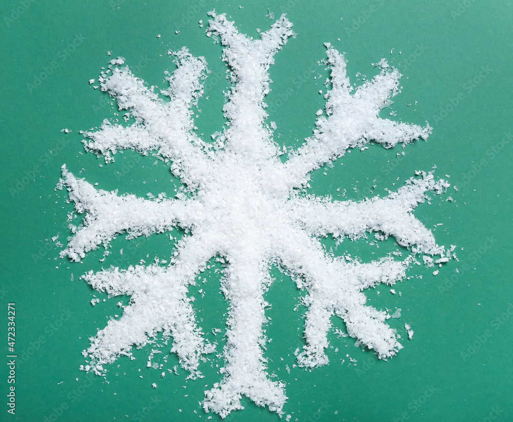 Snowflake made of snow on color background