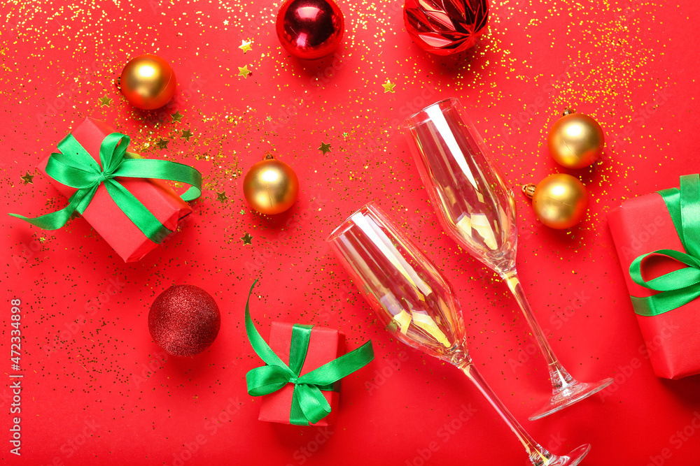 Composition with Christmas gifts, decorations and glasses on red background