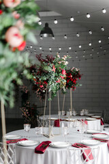 Wall Mural - Canned round tables in the white hall. Wedding decorations made of flowers on the tables. the concept of the holiday.