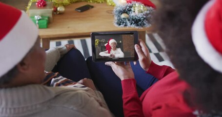 Poster - African american mother and daughter using tablet for christmas video call with woman on screen