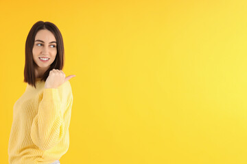 Poster - Attractive girl in sweater on yellow background