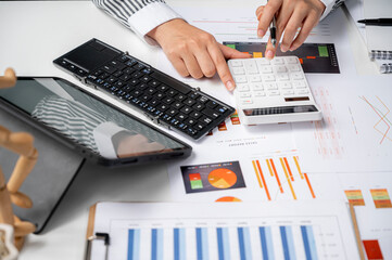 Wall Mural - woman hand working on calculator and portable table analyzing graph chart.