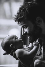 Stylish Caucasian Bearded Father Carrying Newborn Baby On Shoulder. Male Man Parent Holding Child Daughter Son In Arms. Authentic Lifestyle Documentary Moment. Single Dad Family Life Concept