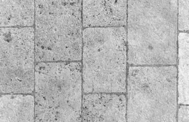 Monochrome old cobblestone pavement texture. Ancient sidewalk ba