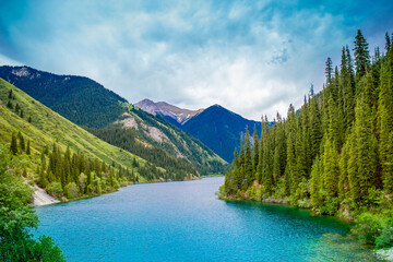 Lake Kaindy sunken forest in Kazakhstan. Beautiful mountain nature landscape. Blue lake Kolsai top view. Panoramic view of the nature reserve.