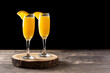 Orange mimosa cocktail on wooden table. Copy space