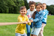 © Syda Productions - childhood, leisure and people concept - group of happy kids playing tug-of-war game and running at park