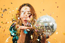 Blurred Happy Girl Blowing Confetti Holding Vintage Disco Ball - Defocused Photo