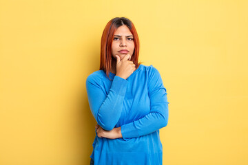 Wall Mural - young hispanic woman looking serious, confused, uncertain and thoughtful, doubting among options or choices