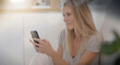 © goodluz - young woman checking her cell phone in her house