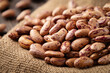 Heap of spotted pinto beans on jute fabric close up