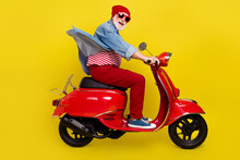 Profile Side View Portrait Of Elderly Retired Pensioner Cheery Man Riding Moped Isolated Over Bright Yellow Color Background