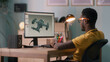 © Framestock - African American man in glasses using computer to create 3D model of aircraft while working at home office
