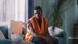 © Framestock - Stressed African American man yawning and taking hardhat then standing up from couch and walking to hated work