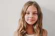 © Westend61 - Smiling girl in front of white wall