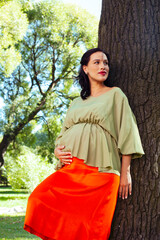 Wall Mural - young pretty brunette pregnant woman outdoor in green park happy smiling, lifestyle people concept