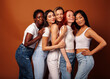 © iordani - young pretty african and caucasian women posing cheerful together on brown background, lifestyle diverse nationality people concept