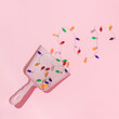 New Year party creative layout with christmas lights decoration in dustpan on pastel pink background. 80s or 90s retro fashion aesthetic concept. New Year celebration idea.