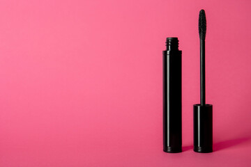 mascara tube and brush on pink background. unbranded mascara bottle with place for text. makeup, vis