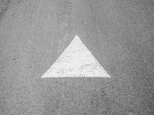 An Arrow Drawn With White Paint On The Asphalt. Direction Indicator.