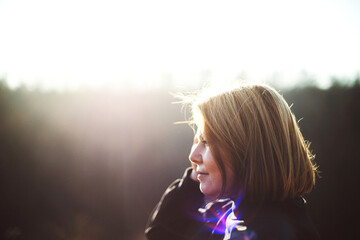 Portrait of adult  woman standing in field  sunset