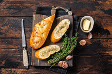Toasted Garlic Bread With Herbs And Butter On Wooden Cutting Board. Wooden Background. Top View