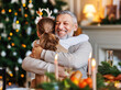 © JenkoAtaman - Little girl granddaughter embracing happy smiling grandfather during Christmas dinner at home