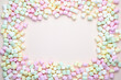 © Claudia Nass - colorful frame of small marshmallows on pastel colored background with copy space