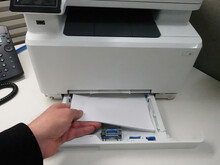 Man Loading Paper Into Printer Paper Tray
