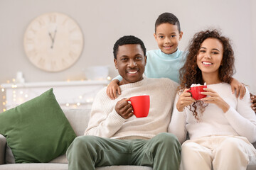 Poster - Happy African-American family drinking tasty hot chocolate at home on Christmas eve