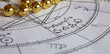 Detail of an astrological chart with Mercury, Uranus, Pluto and Venus  planets, Christmas decoration in the background