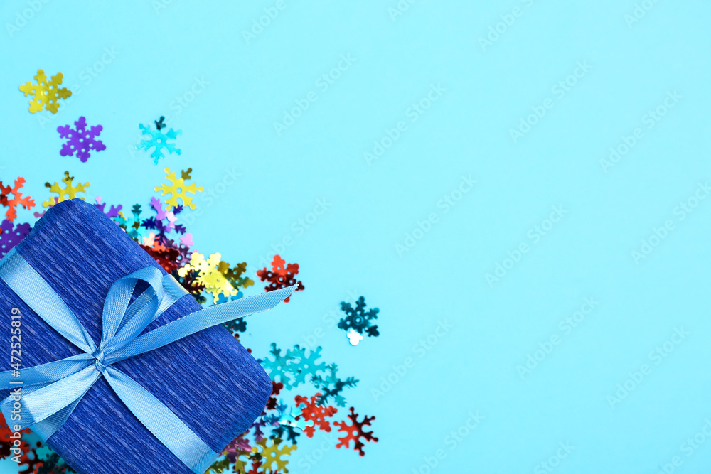 Christmas gift and beautiful confetti on color background, closeup