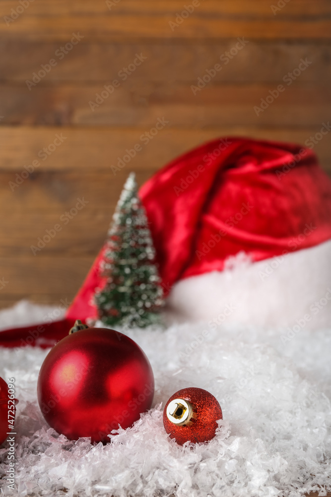 Christmas decorations and snow on wooden background