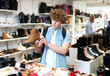 © JackF - Focused teenager looking for comfortable demi-season mens shoes in modern shoe store.