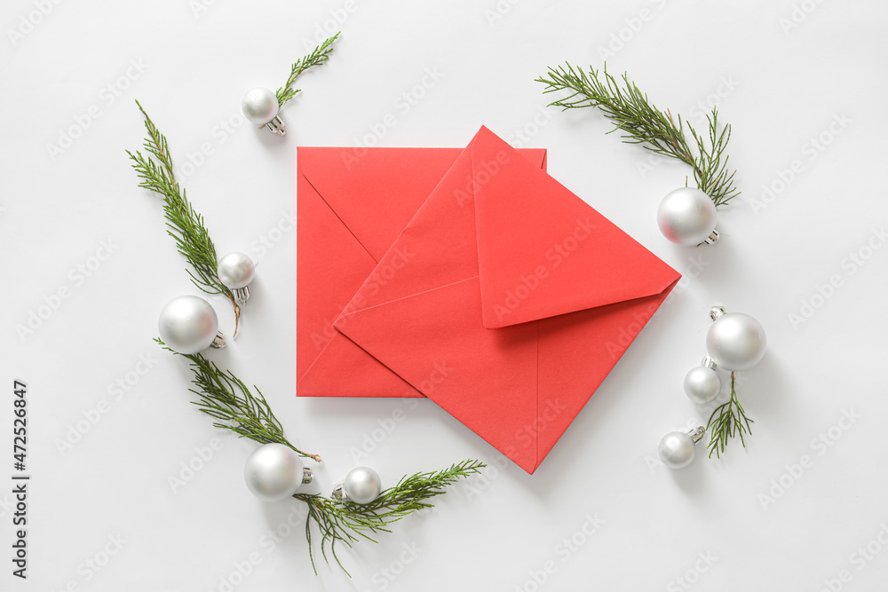 Composition with envelopes, coniferous branches and Christmas decorations on white background