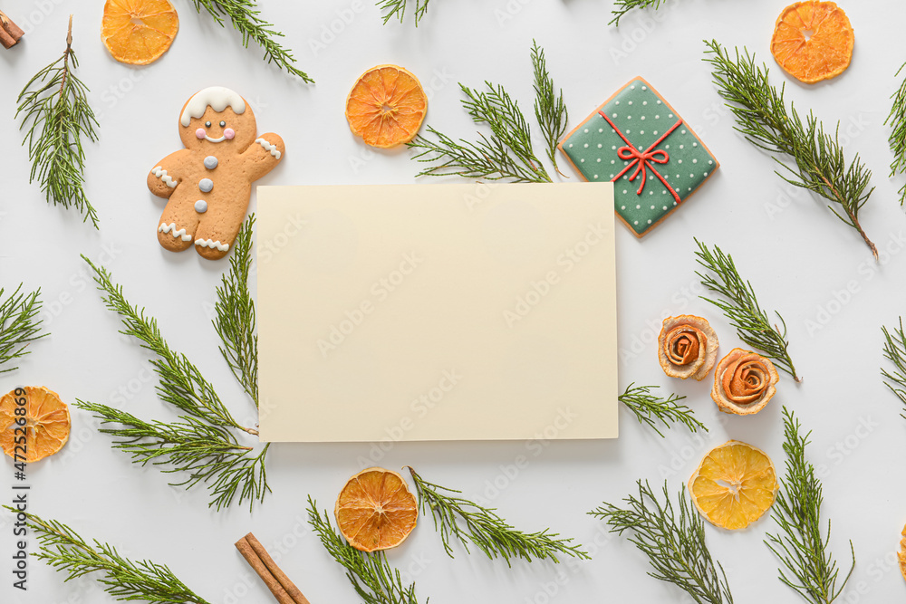 Blank card, cookies, dried orange slices and coniferous branches on white background