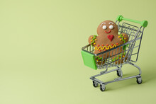 Shopping Cart With Gingerbread Man On A Light Green Background As A Symbol Of Christmas And New Year Shopping. Copy Space, Horizontal Orientation.