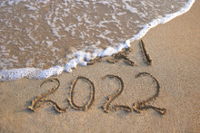 2021, 2022 Years Written On Sandy Beach Sea. Wave Washes Away 2021.