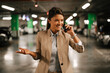 © JustLife - Businesswoman in suit unlocking car on parking. Beautiful woman talking to the phone..