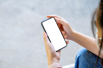 A woman holding a cell phone with a blank white screen. The blank space on the white screen can be used to write a message or place an image.