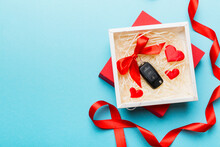 Black Car Key In A Present Box With A Ribbon And Red Heart On Colored Background. Valentine Day Composition Top View