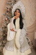 © Тамара Киреева - a beautiful dark-haired girl in a snow maiden costume stands at the Christmas tree