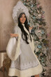© Тамара Киреева - a beautiful dark-haired girl in a snow maiden costume stands at the Christmas tree