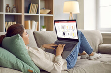 Young Woman Lying Relaxing On Sofa At Home Shopping Online On Internet On Computer. Millennial Girl Rest Couch Buy Purchase On Laptop Black Friday Or Seasonal Sales. Promotion And Discount.