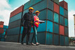 © InfiniteFlow - Industrial worker works with co-worker at overseas shipping container yard . Logistics supply chain management and international goods export concept .