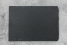 Slate Plate On Gray Stone Texture Background. Kitchen Stone Tray For Serving Food. Black Granite Rectangle Board. Empty Space For Menu Or Recipe. Top View Copy Space, Mockup