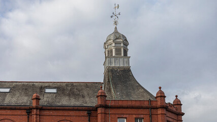 ornate top of tower in red brick building