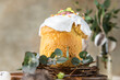 Easter composition with traditional Orthodox sweet bread. Kulich decorated with meringue icing and candy shaped eggs.